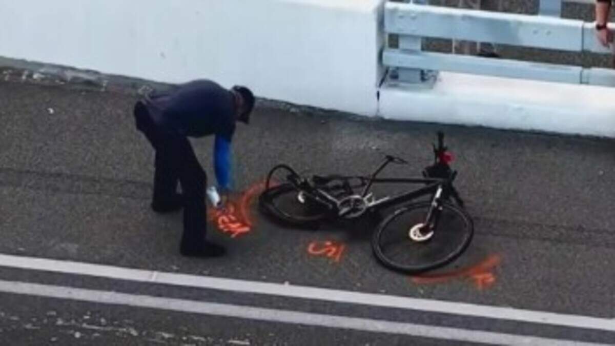 An investigator silhouettes a bicycle with evidence paint on the Southeast 17th Street Causeway Bridge on Thursday, June 25, 2026, in Fort Lauderdale.
